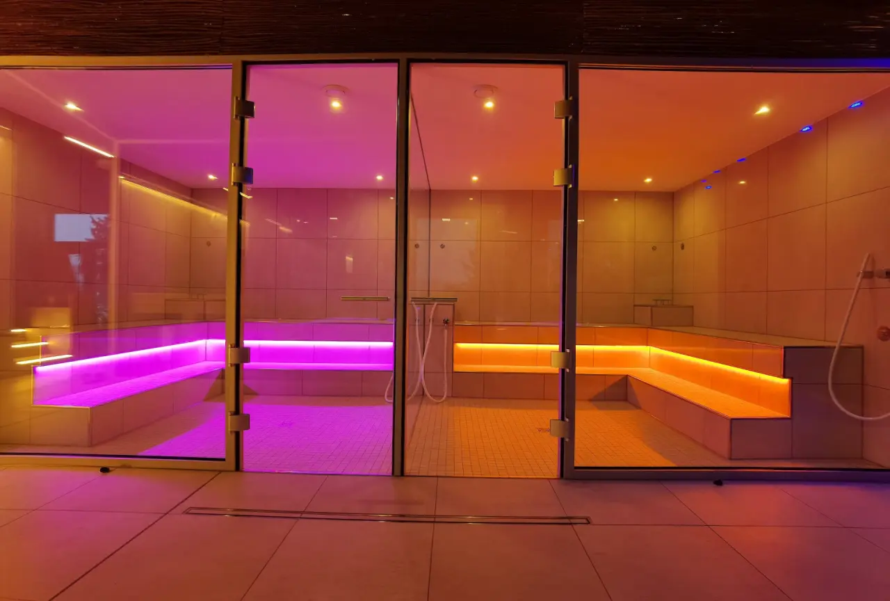 Zwei moderne Dampfbäder mit farbiger LED-Beleuchtung (Pink und Orange) im Spa-Bereich des Hotel & Residence Hochriegel.