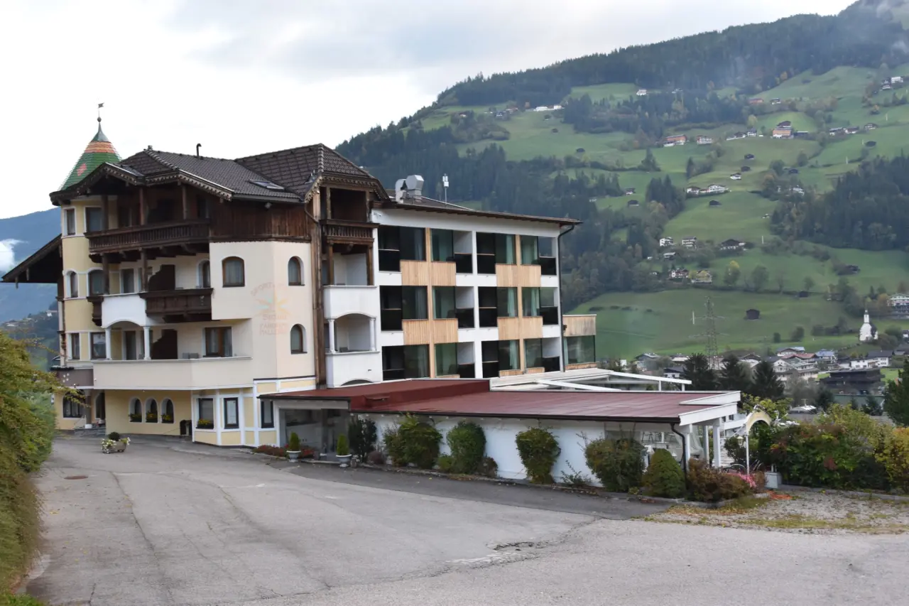 Aussenansicht des Hotel Stefanie Sport & Vital mit traditioneller Architektur und modernem Anbau vor grüner Berglandschaft.