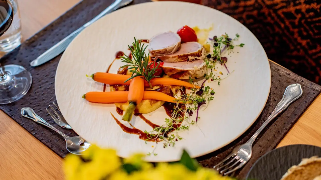 Fein angerichteter Schweinefilet-Teller mit Karotten und Kräutern im Restaurant des Pfalzblick Wald Spa Resort.