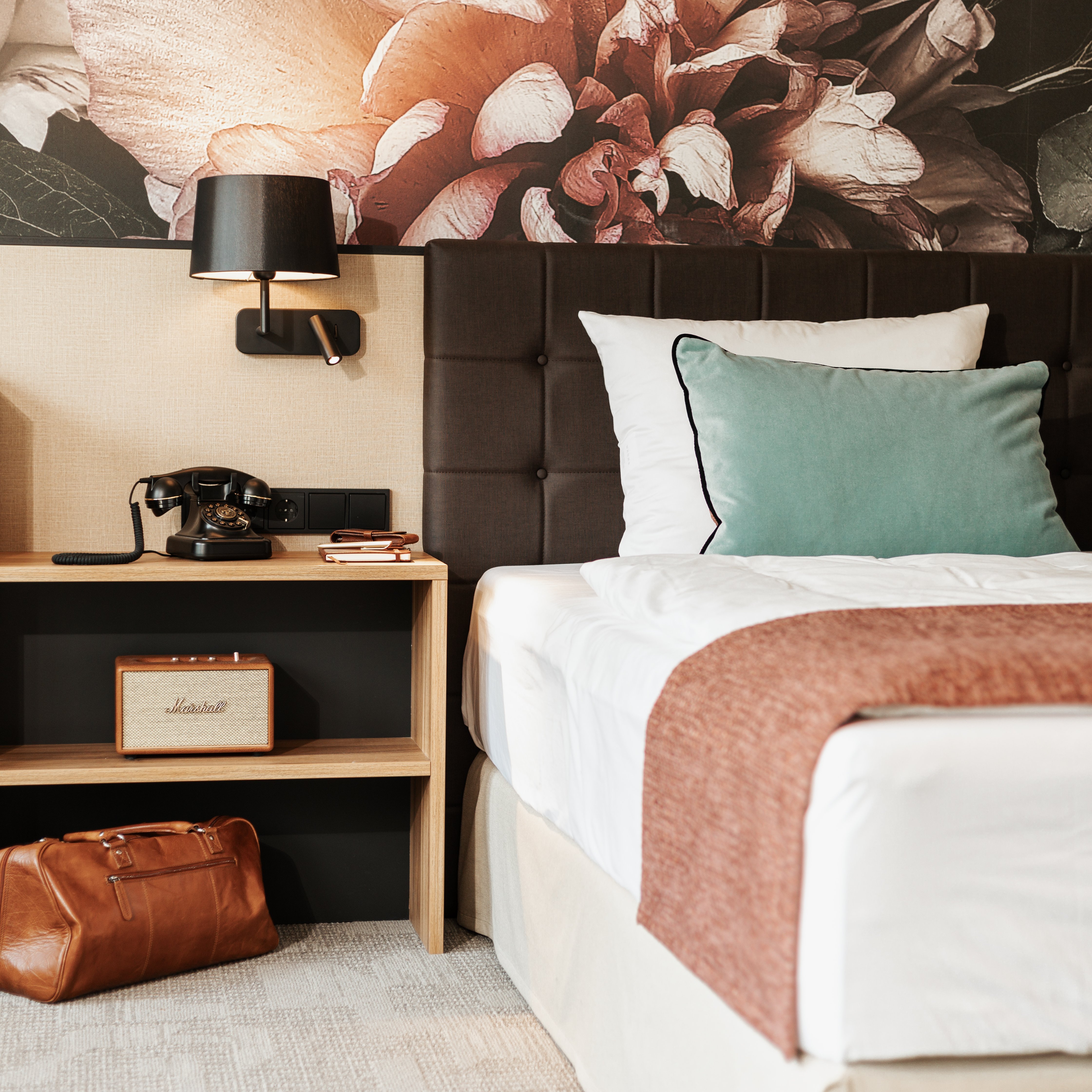 Dreiklang Business & Spa Resort in Kaltenkirchen – Modernes Hotelzimmer mit Nachttisch und floraler Tapete | Wellnesshotel Schleswig-Holstein