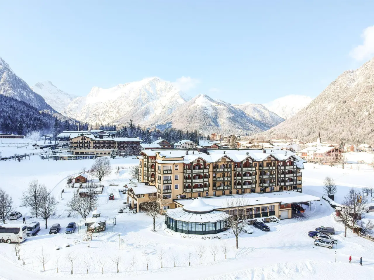 Panoramablick auf das Hotel der Wiesenhof im Winter, umgeben von verschneiten Bergen und einer idyllischen Landschaft.