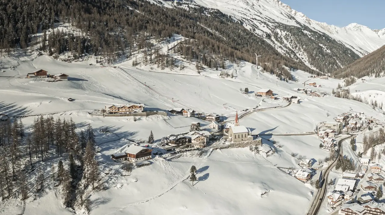 Hotel Berger in Rein in Taufers – Panorama-Außenansicht des verschneiten Bergdorfs im Winter | Wellnesshotel Südtirol