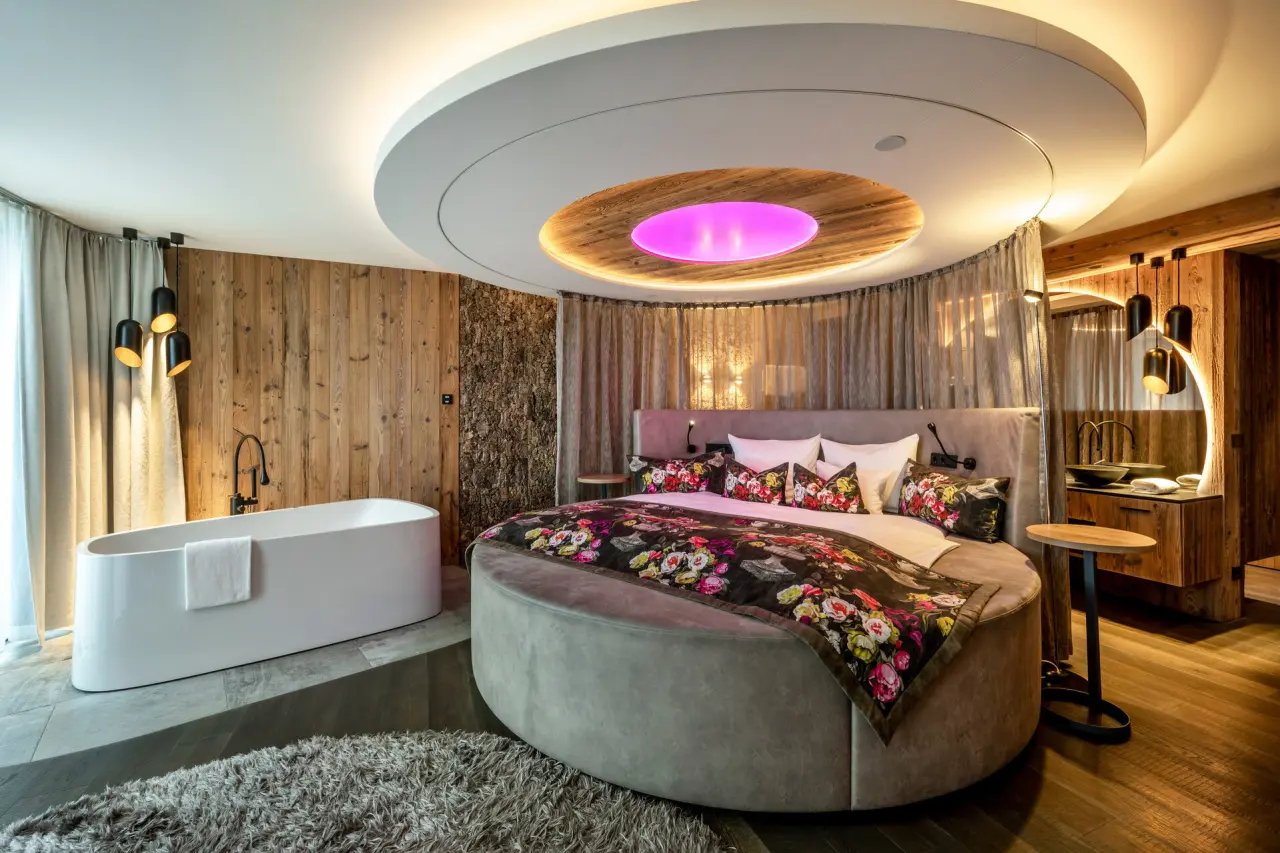 Luxuriöses Hotelzimmer mit rundem Bett und freistehender Badewanne im Wellnesshotel Hüttenhof ****S.