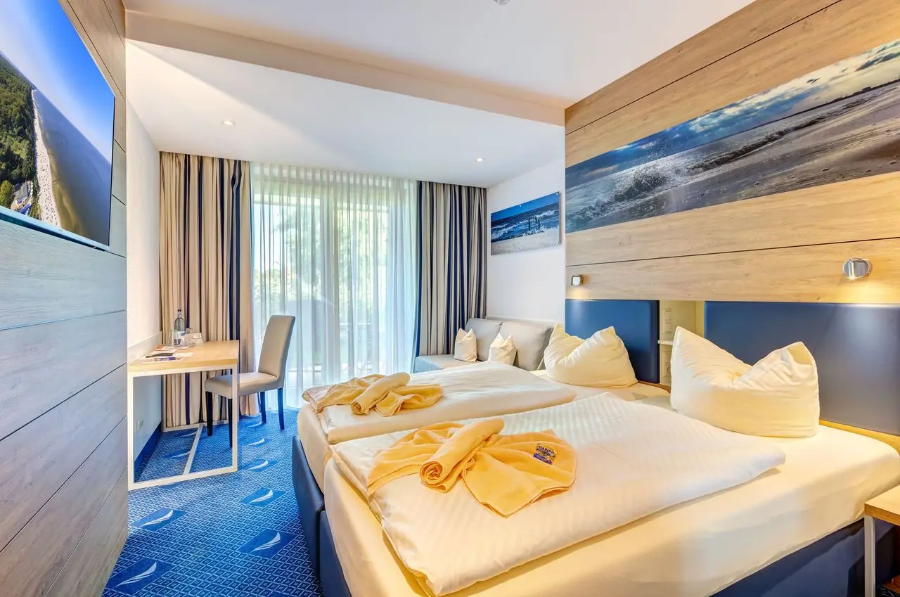 Modernes Doppelzimmer im Familien Wellness Hotel Seeklause mit Balkon, Schreibtisch und maritimem Design.