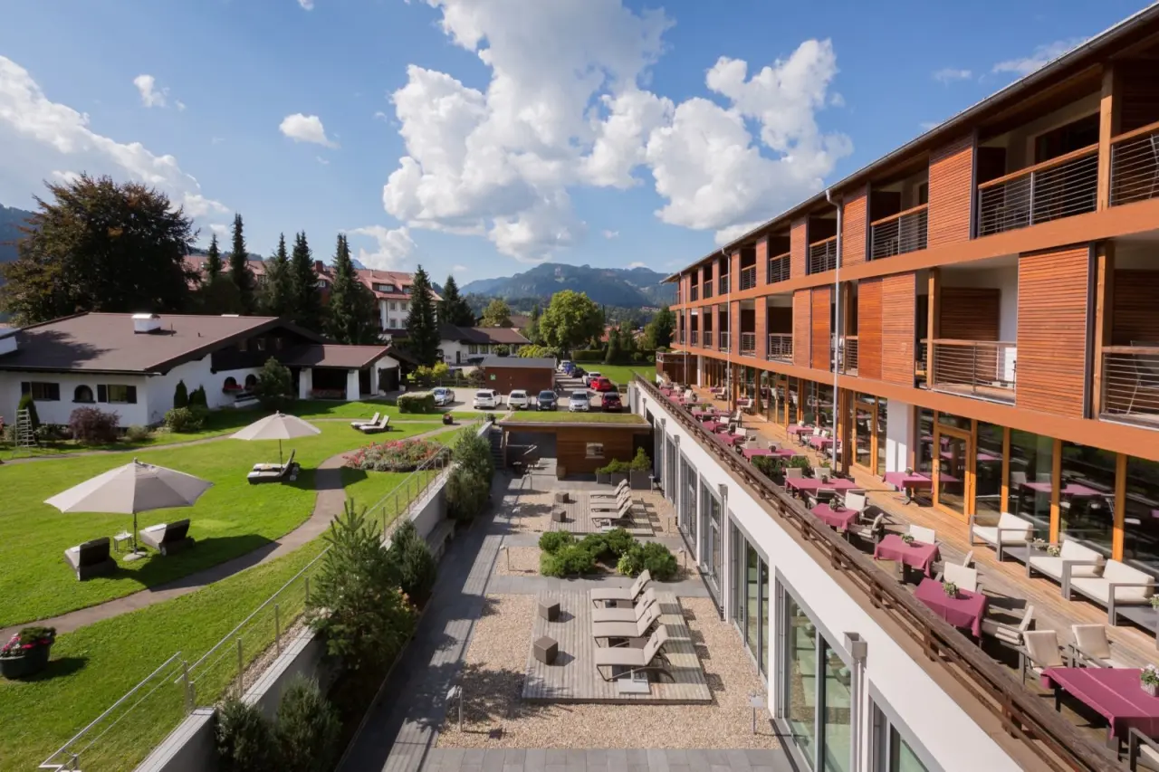 Hotel Exquisit in Oberstdorf – Moderne Außenansicht mit Gartenanlage und Bergblick | Wellnesshotel Allgäu