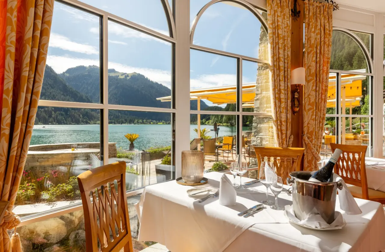Restaurant im Hotel Via Salina mit elegant gedecktem Tisch und Panoramablick auf den See und die Berge.