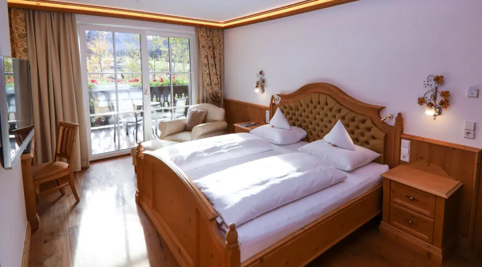 Gemütliches Doppelzimmer mit Holzelementen, Balkon und Bergblick im Hotel Via Salina. Ideal für entspannte Nächte.