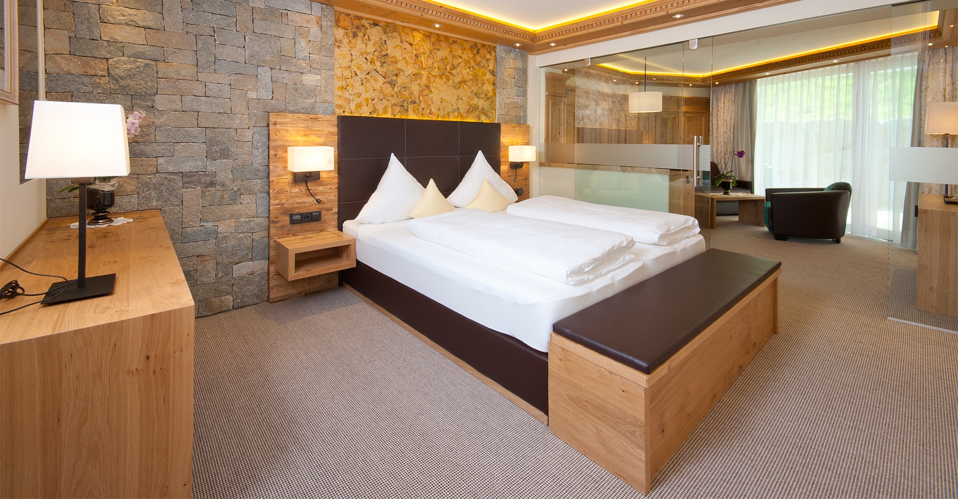 Hotel Tirol Alpin SPA in Ischgl – Geräumiges Doppelzimmer mit Steinwand und modernem Design | Wellnesshotel Tirol