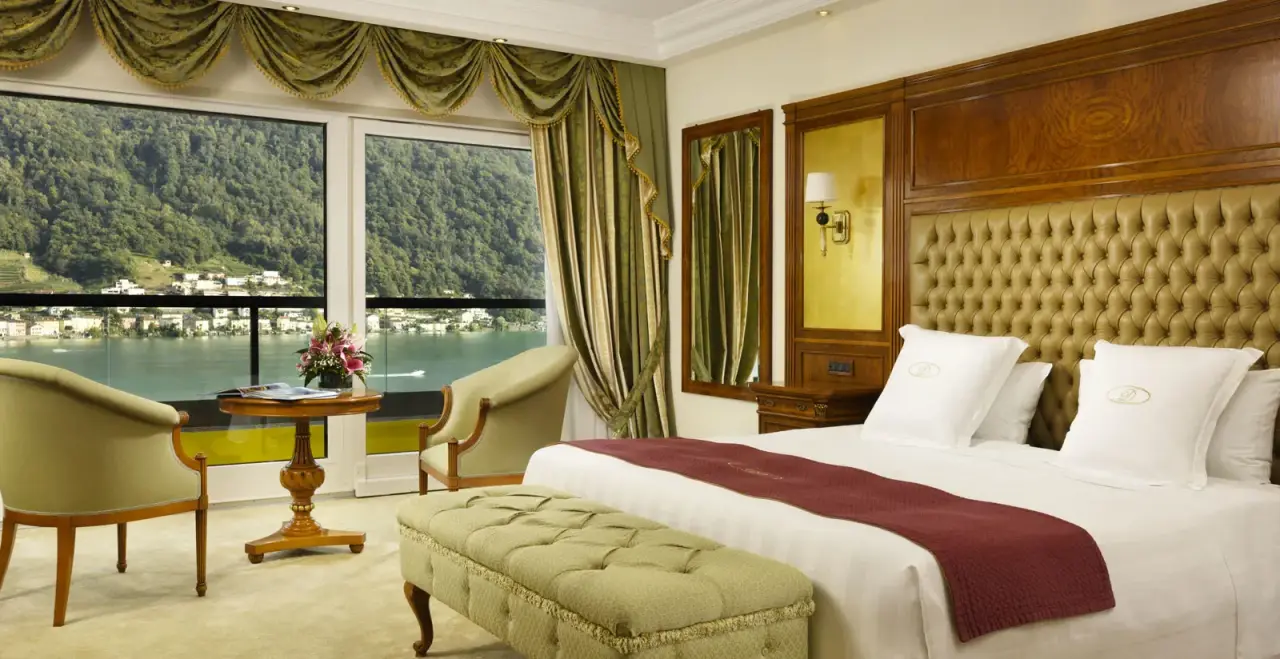 Luxuriöses Hotelzimmer im Swiss Diamond Hotel mit Seeblick auf den Luganersee und die umliegenden Berge.