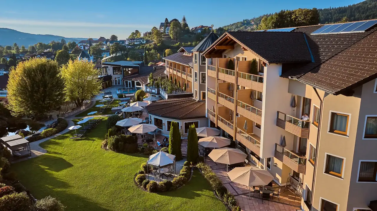 Panoramablick auf das Kristall & Vitalhotel Bergknappenhof mit Garten, Sonnenterrassen und umliegender Berglandschaft.