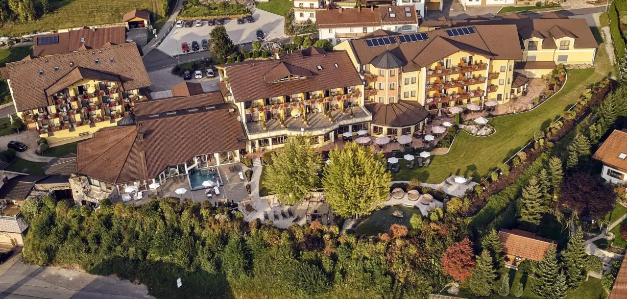 Luftaufnahme des Kristall & Vitalhotel Bergknappenhof mit Hotelanlage, Aussenpool und weitläufigem Gartenbereich.