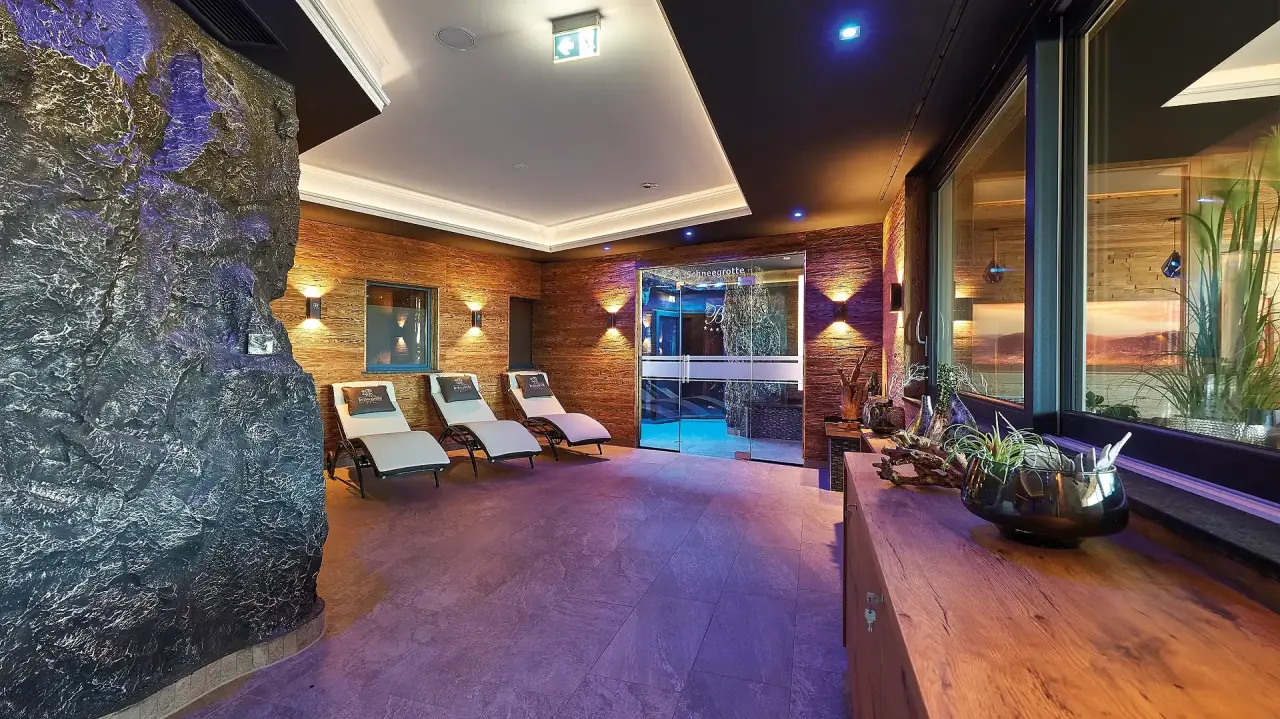 Entspannungsbereich mit Liegen und Zugang zur Schneegrotte im Spa des Kristall & Vitalhotel Bergknappenhof.