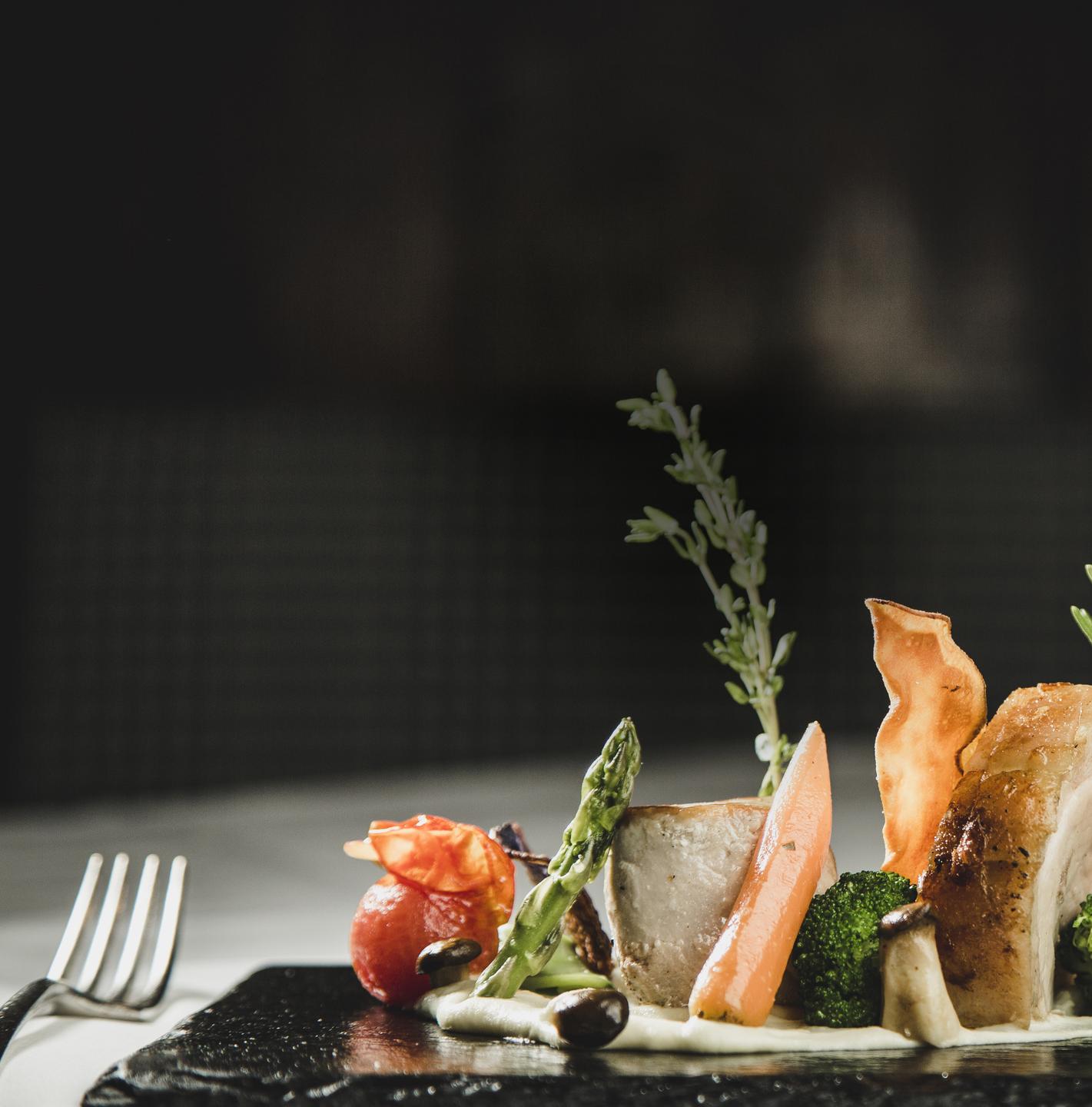 Hotel Schwarzer Adler in St. Anton am Arlberg – Gourmetgericht mit Gemüse und Fleisch auf schwarzem Teller | Wellnesshotel Arlberg