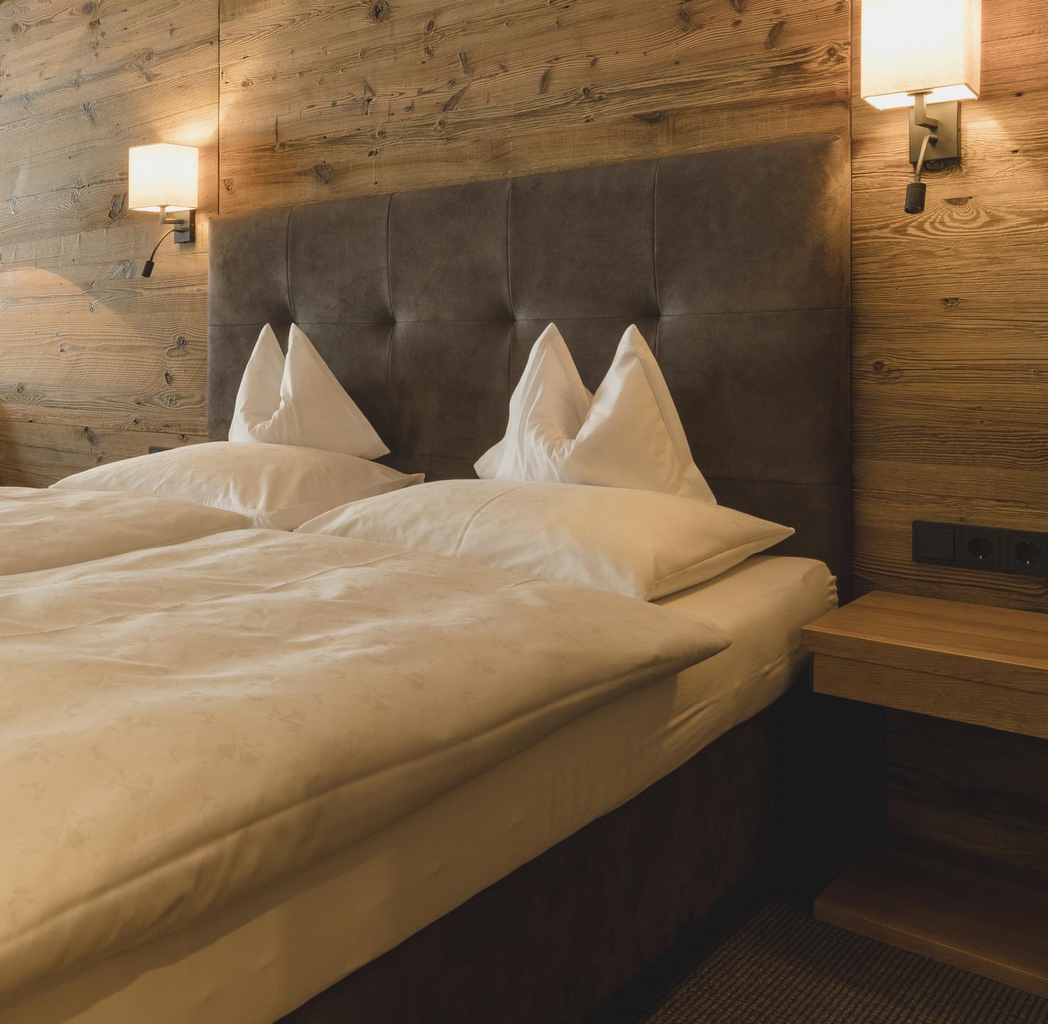 Hotel Schwarzer Adler in St. Anton am Arlberg – Gemütliches Doppelbett in einem Hotelzimmer | Wellnesshotel Arlberg