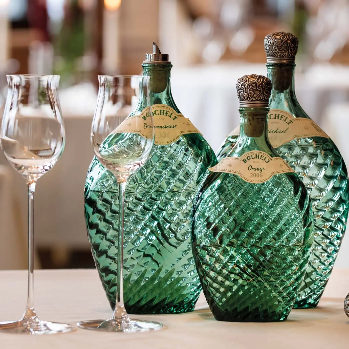 Romantik Hotel Im Weissen Rössl in St.Wolfgang – Dekorative grüne Glasflaschen und Gläser auf einem Tisch | Wellnesshotel Salzkammergut