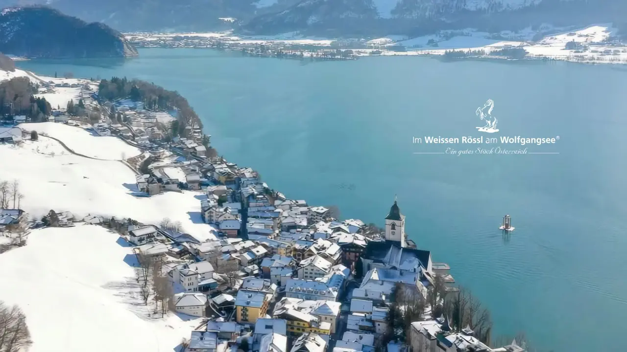 Winterlandschaft am Wolfgangsee mit verschneitem St. Wolfgang und dem Romantik Hotel Im Weissen Rössl.