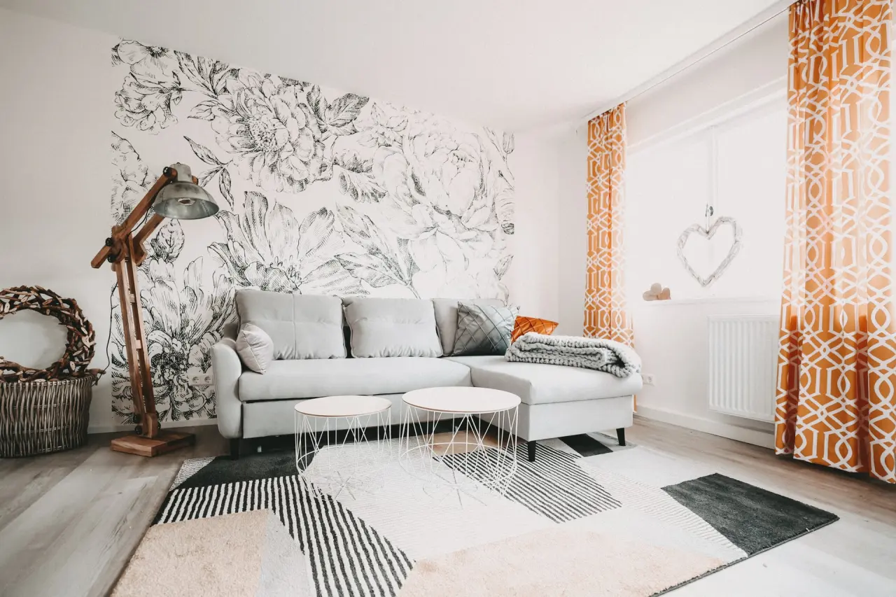 Gemütlicher Wohnbereich einer Suite im Hotel Lauterbad mit Sofa, floraler Wandkunst und stilvollen Vorhängen.