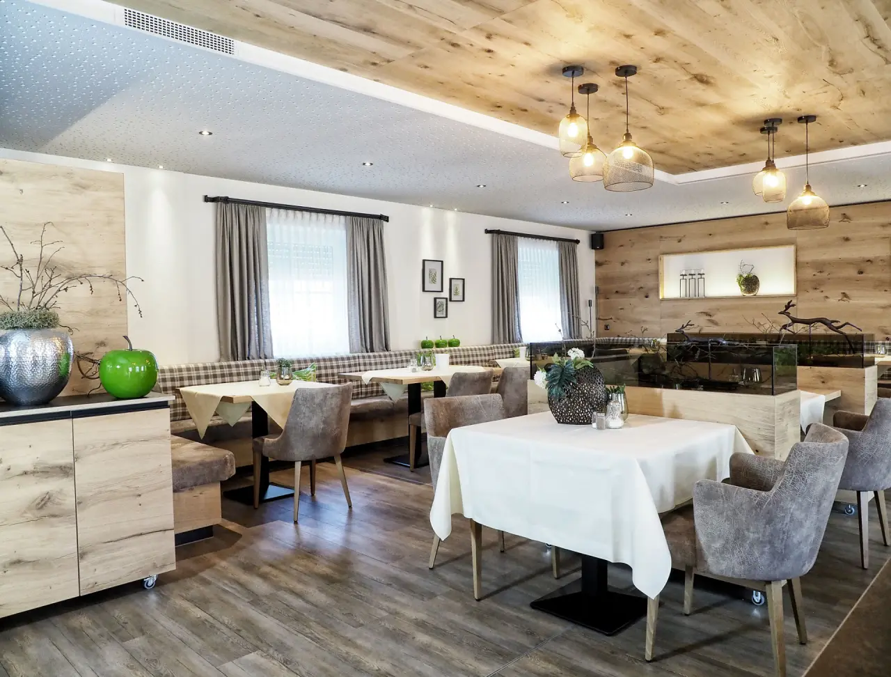 Gemütliches Restaurant im Landhotel Brandlhof mit modernen Holzmöbeln, bequemen Sitzbänken und stilvoller Beleuchtung.