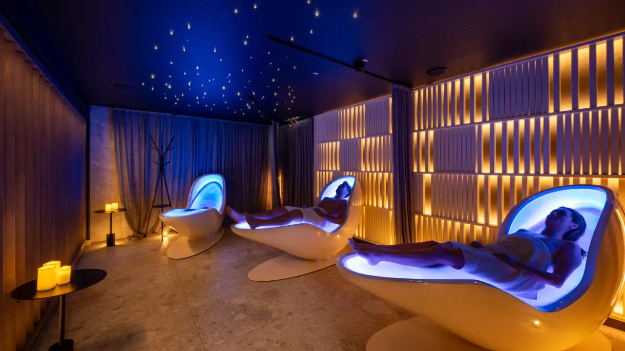 Moderner Ruheraum mit beleuchteten Schwebeliegen und Sternenhimmel im Spa des Angerhof Sport- & Wellnesshotels.