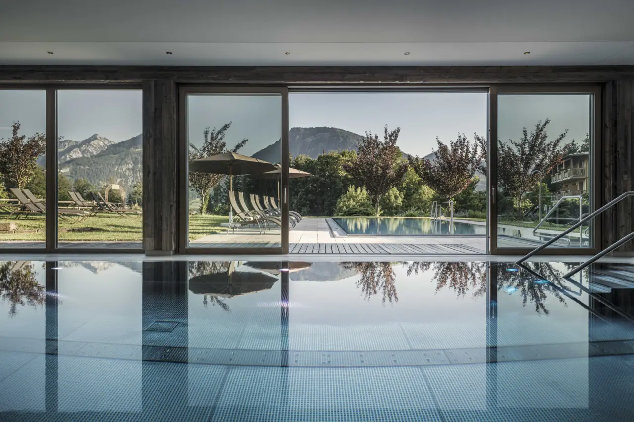 Grosszügiger Innen- und Aussenpoolbereich mit Bergblick im Wellnesshotel Bachmanngut