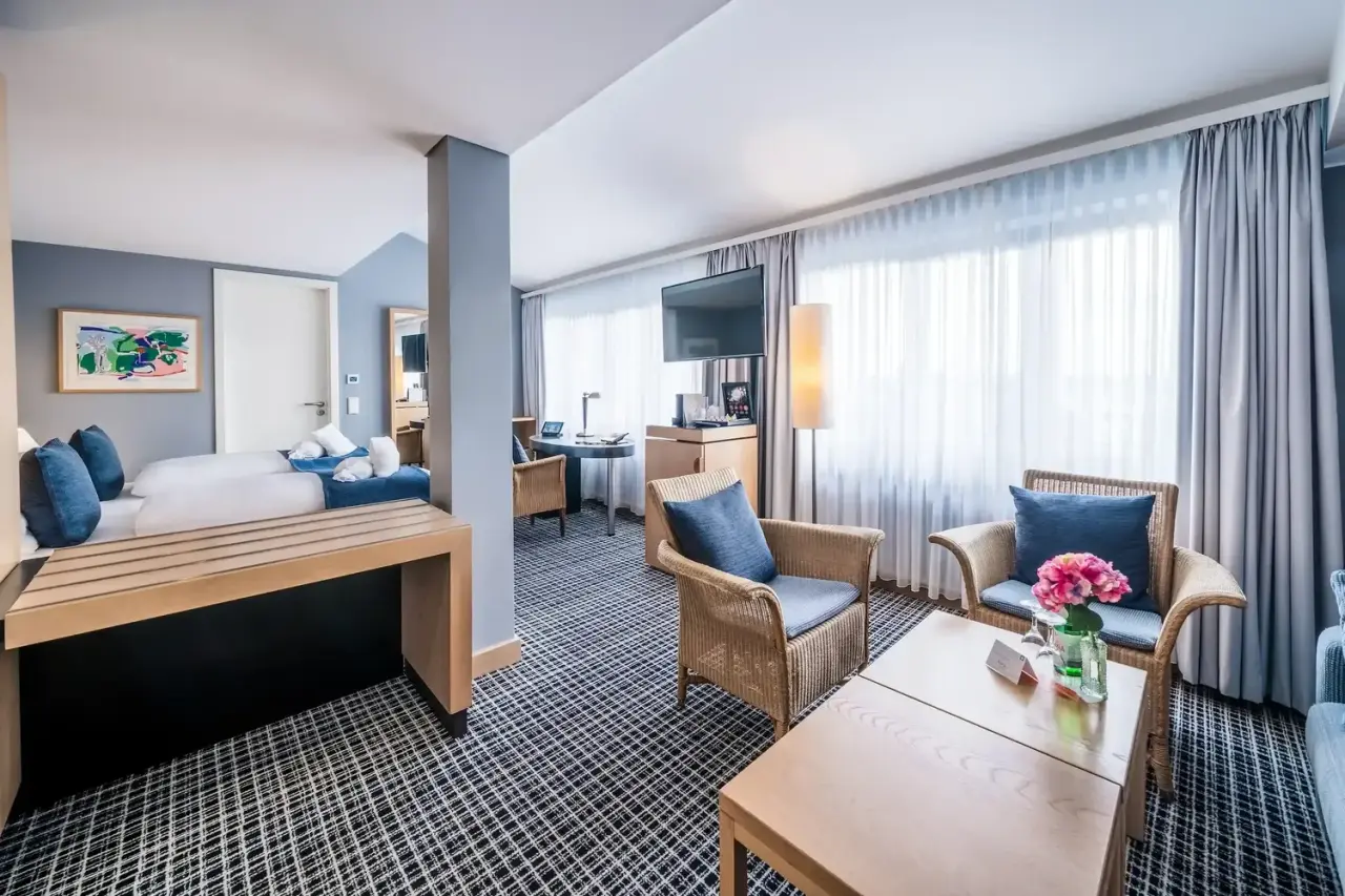 Geräumige Suite im Hotel Esplanade Resort & Spa mit Doppelbett, gemütlichem Wohnbereich und modernen Möbeln.