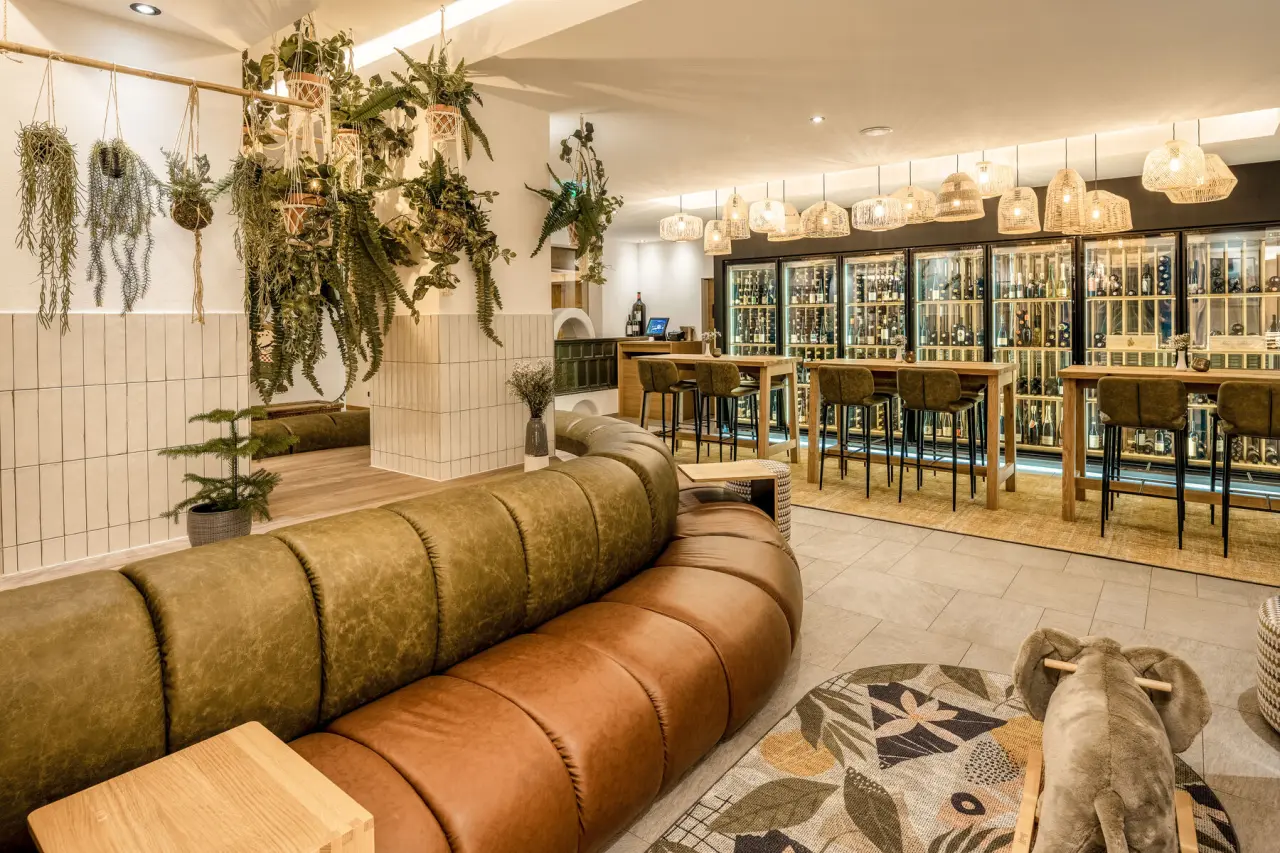 Stilvolle Lounge mit Weinbar und gemütlichen Sitzgelegenheiten im Posthotel Serfaus.