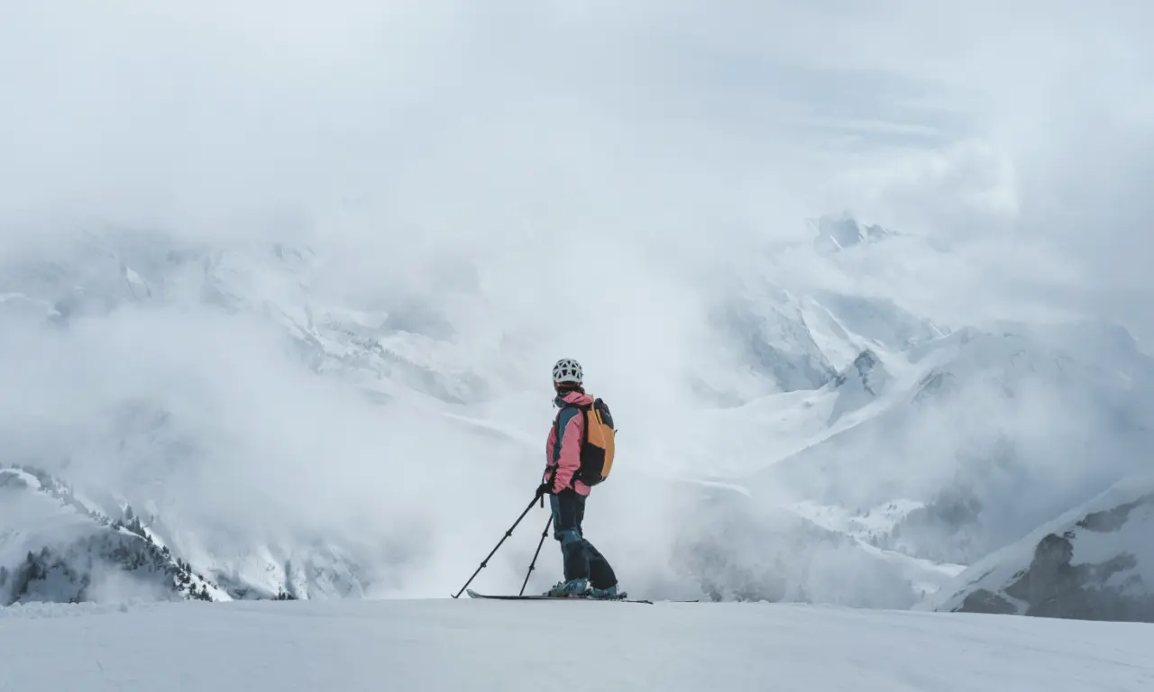Skifahrer in nebelverhangener Winterlandschaft mit schneebedeckten Bergen bei den Amrai Suites.