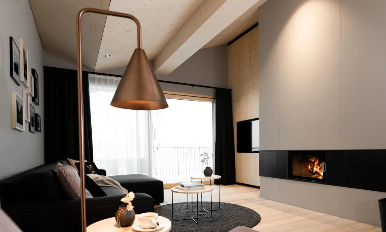 Moderne Suite im Amrai Suites mit gemütlichem Kamin, stilvoller Einrichtung und Balkonblick für entspannte Stunden.