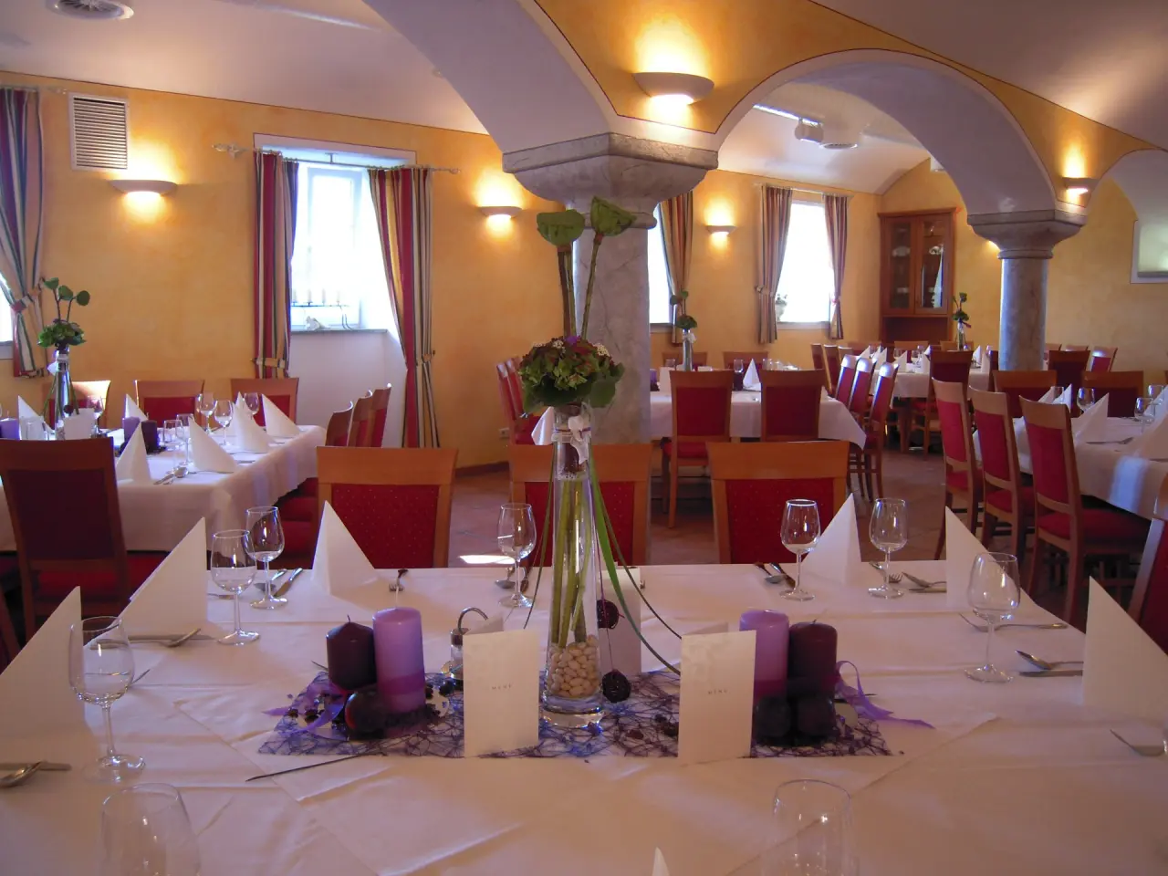 Gemütlicher Speisesaal im Hotel Gasthof Enichlmayr mit festlich gedeckten Tischen und traditionellem Ambiente.