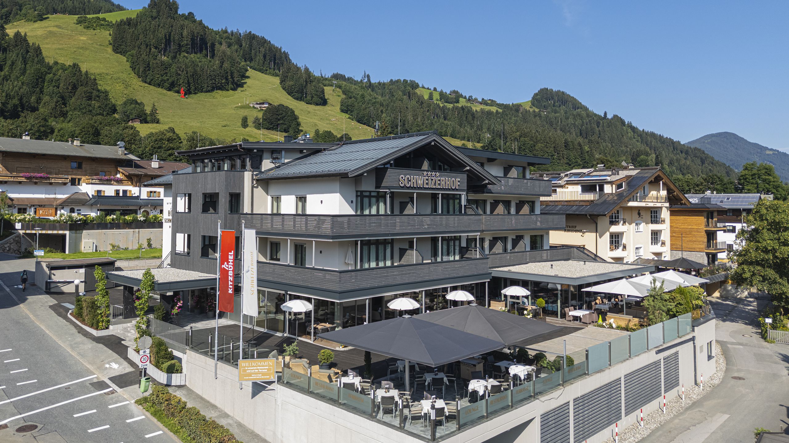 Sport- & Beautyhotel Schweizerhof in Kitzbühel – Hotelansicht im Sommer mit Terrasse | Wellnesshotel Tirol