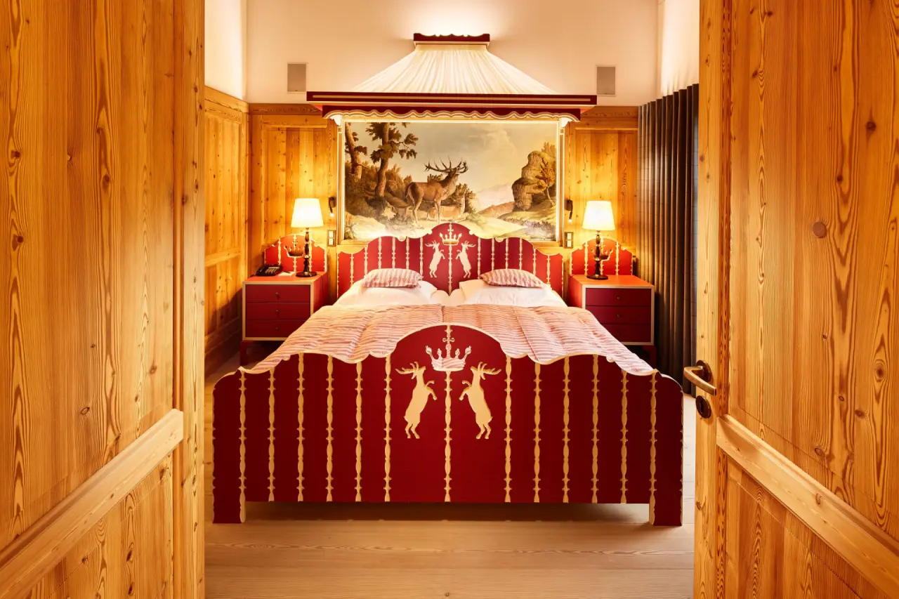 Traditionelles Doppelzimmer mit Zirbenholz und handbemaltem Bett im Hotel Post Lech