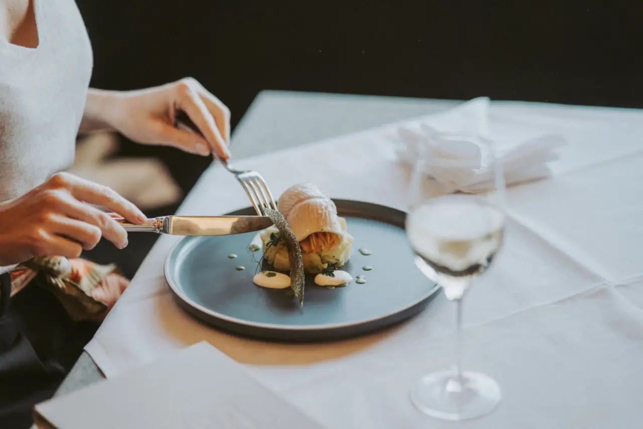 Gast beim Genuss eines exquisiten Gerichts mit Wein im Restaurant von Mein Hotel Fast.