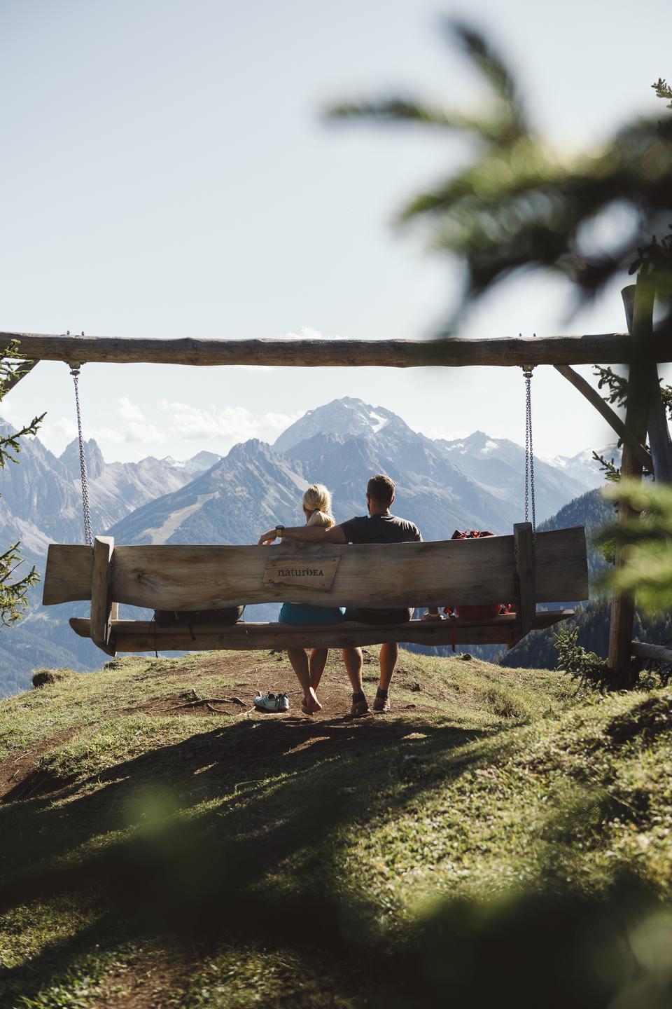 Sporthotel Neustift in Neustift im Stubaital – Paar auf Bergschaukel mit Alpenpanorama | Wellnesshotel Stubaital