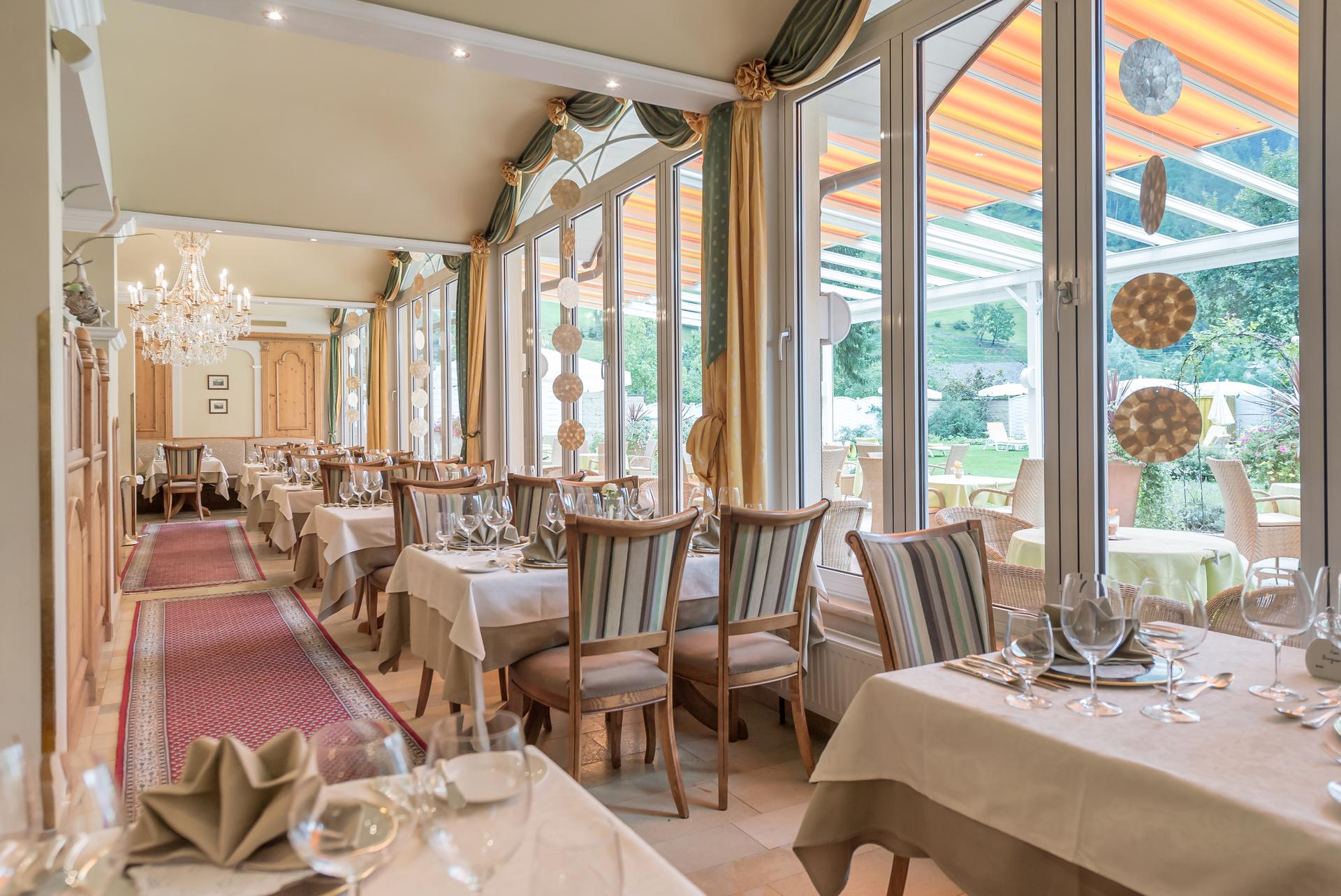 Sporthotel Neustift in Neustift im Stubaital – Helles Restaurant mit Gartenausblick und gedeckten Tischen | Wellnesshotel Stubaital