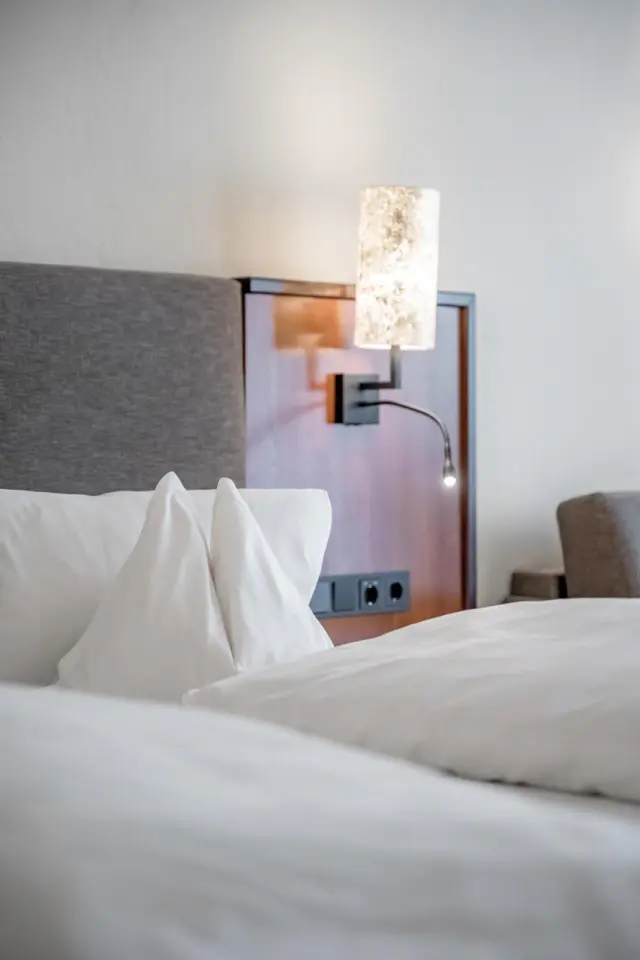 Sporthotel Neustift in Neustift im Stubaital – Detailansicht eines Hotelbettes mit Nachttischlampe | Wellnesshotel Stubaital