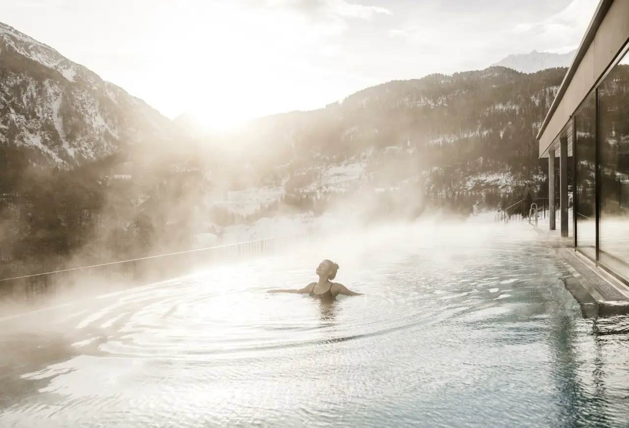 Beheizter Infinity Pool mit Dampf und Panoramablick auf die verschneiten Alpen im Sportlers Lodge Sölden.