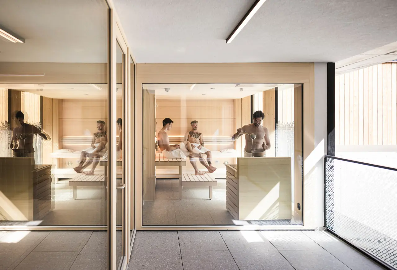 Moderne finnische Sauna mit Gästen und Aufguss in der Sportlers Lodge Sölden