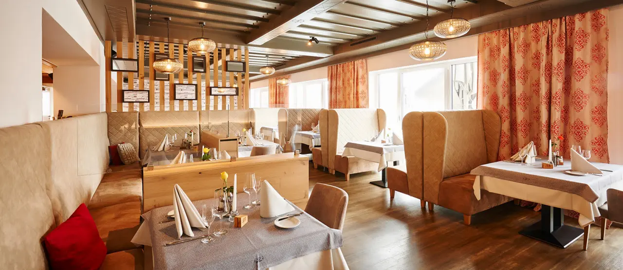 Einladendes Restaurant im Wellnesshotel Zum Koch mit gemütlichen Sitzbereichen und elegant gedeckten Tischen.