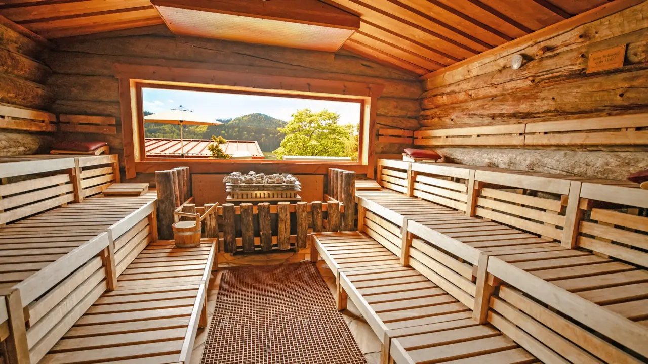 Gemütliche Holzsauna mit Panoramafenster und Bergblick im Wellnesshotel Hofbräuhaus.