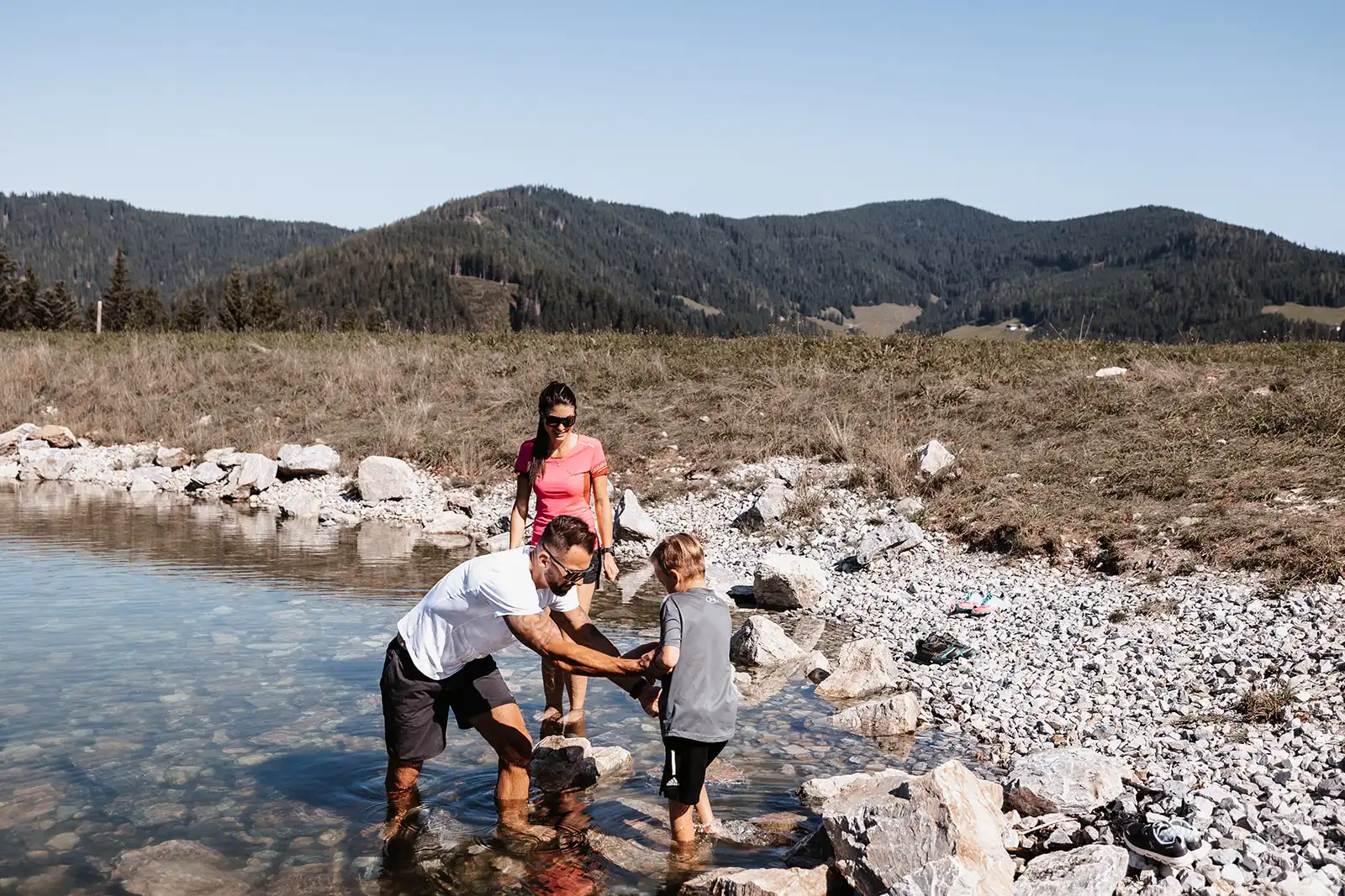 Hofgut Apartment & Lifestyle Resort Wagrain in Wagrain – Familie beim Spielen im Gebirgsbach in den Alpen | Wellnesshotel Salzburger Land