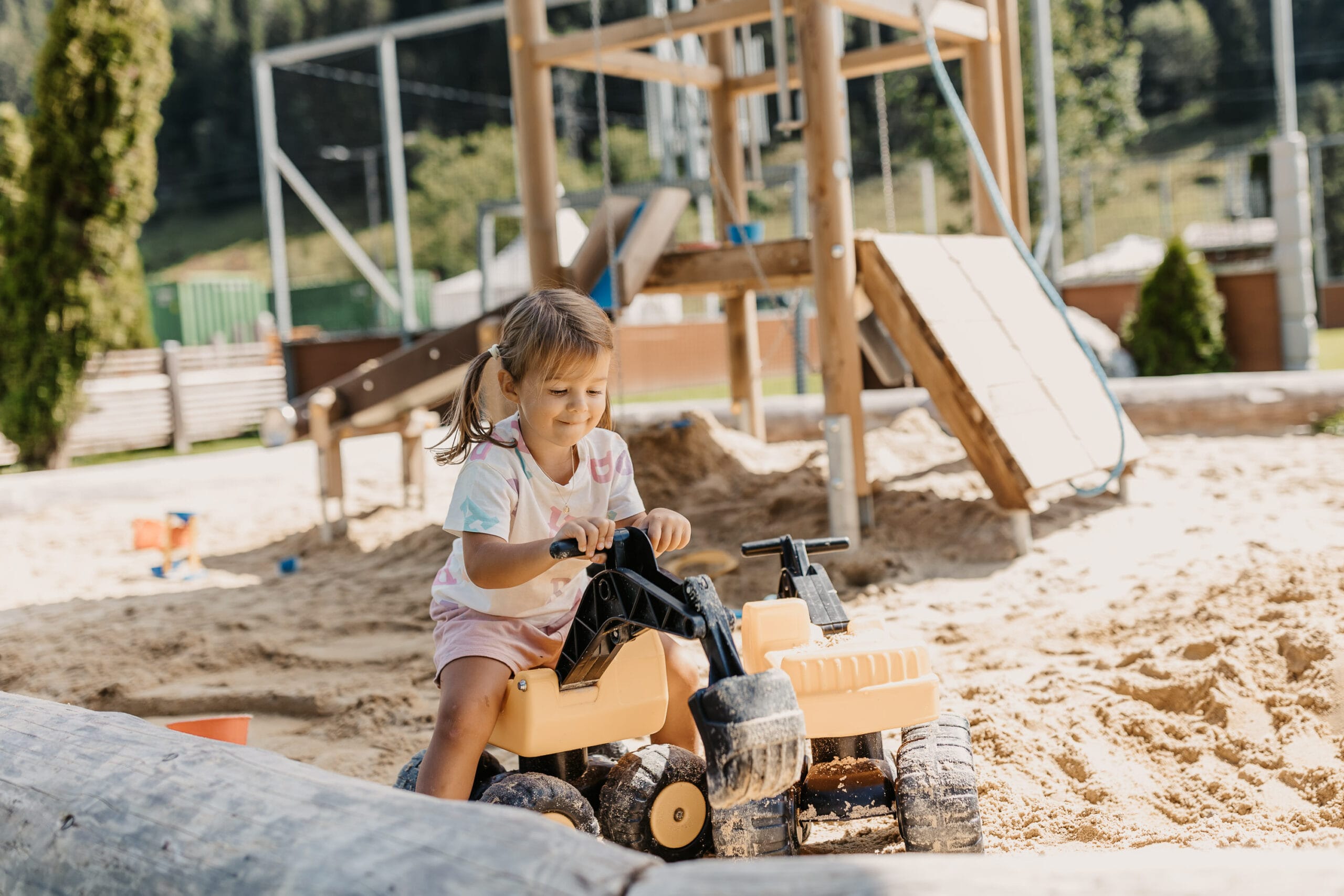 Hofgut Apartment & Lifestyle Resort Wagrain in Wagrain – Kleines Mädchen spielt im Sandkasten auf dem Spielplatz | Wellnesshotel Salzburger Land