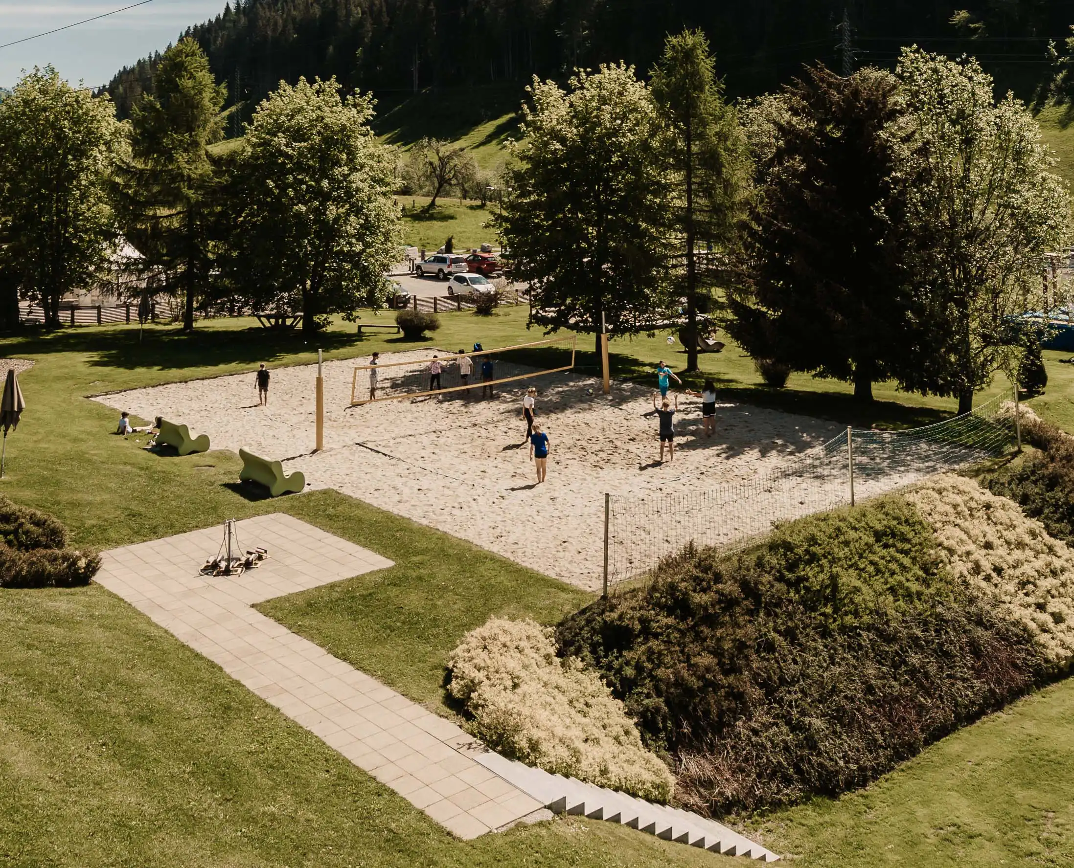 Hofgut Apartment & Lifestyle Resort Wagrain in Wagrain – Beachvolleyballfeld im Grünen mit spielenden Gästen | Wellnesshotel Salzburger Land