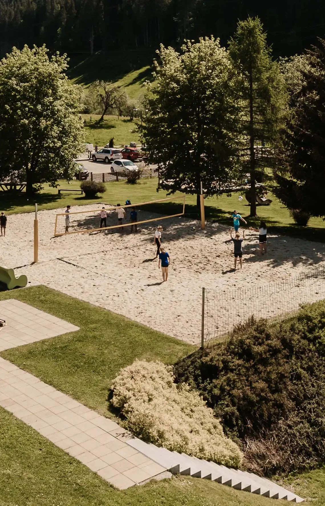 Hofgut Apartment & Lifestyle Resort Wagrain in Wagrain – Gäste spielen Beachvolleyball auf dem Sandplatz | Wellnesshotel Salzburger Land