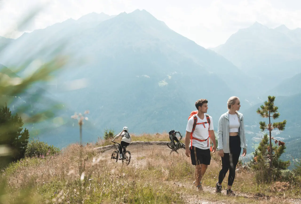 Wanderer und Mountainbiker in der alpinen Landschaft des Ötztals, nahe dem Aparthotel Grünwald Resort Sölden.