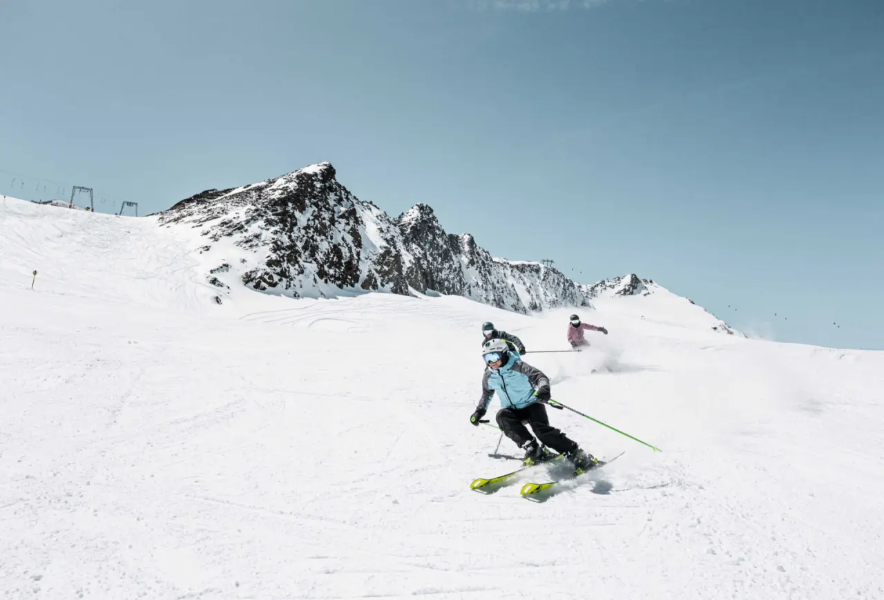 Skifahrer auf verschneiter Piste mit Alpenpanorama in Sölden. Wintererlebnis nahe Aparthotel Grünwald Resort Sölden.