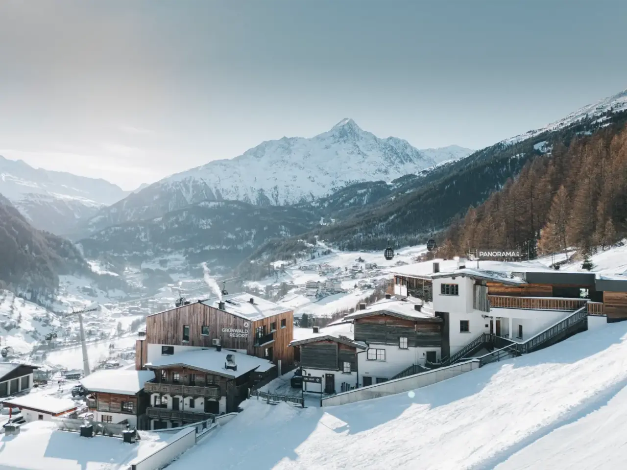 Aparthotel Grünwald Resort Sölden in verschneiter Alpenlandschaft mit Blick auf die Berge und Skipisten.