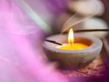 Kerze und Räucherstäbchen mit Rauch für Entspannung im Vital- und Wellnesshotel Albblick.