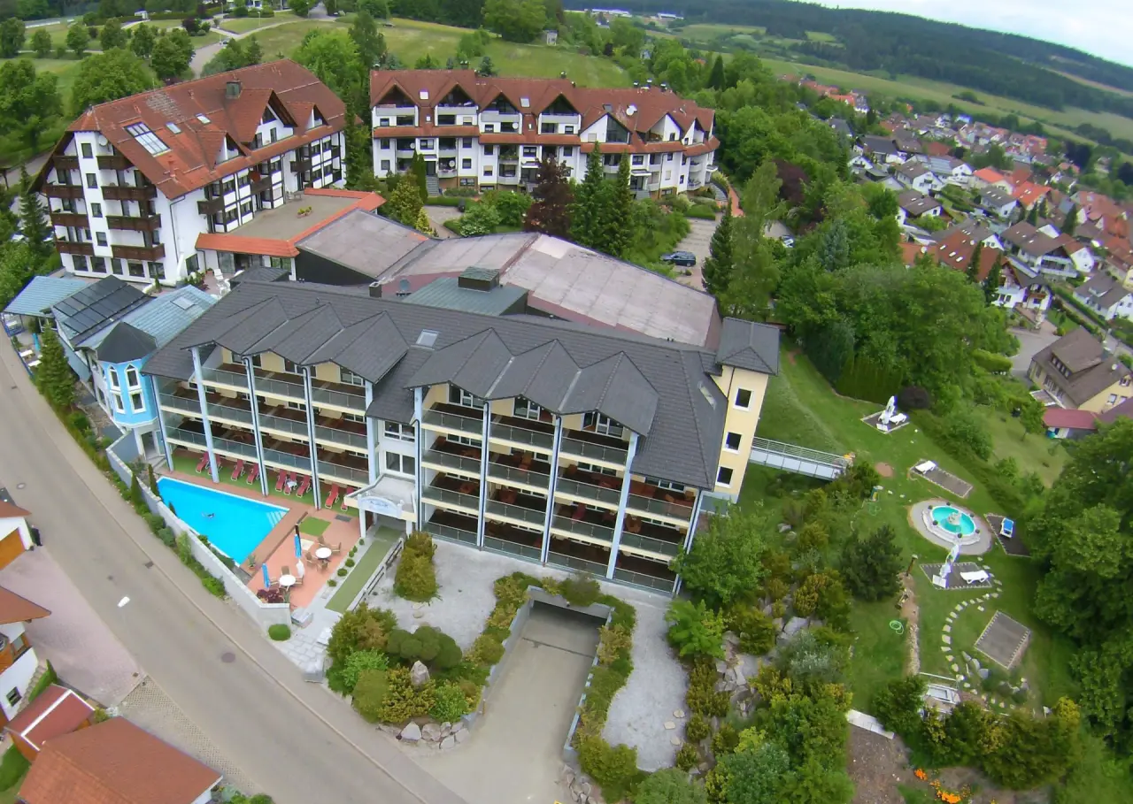Panoramablick auf das Vital- und Wellnesshotel Albblick mit Hotelanlage, Aussenpool und idyllischer Umgebung.