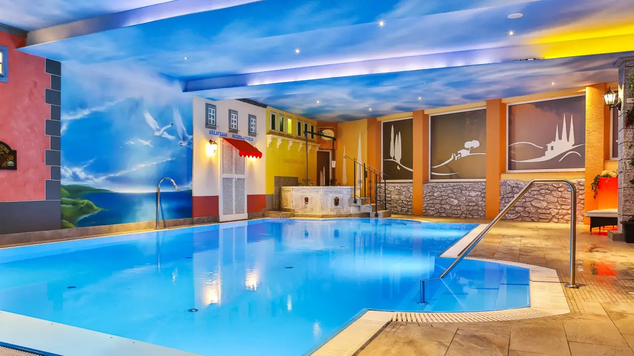Grosser Innenpool mit mediterraner Wandgestaltung und Sternenhimmel im Vital- und Wellnesshotel Albblick.