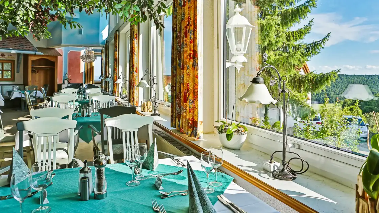Heller Restaurantbereich mit Blick ins Grüne und elegant gedeckten Tischen im Vital- und Wellnesshotel Albblick.